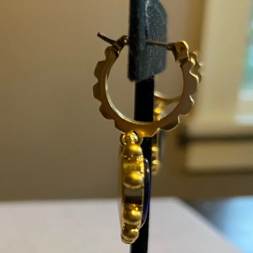 Tory Burch blue lapis heart drops hanging from huggie hoops.